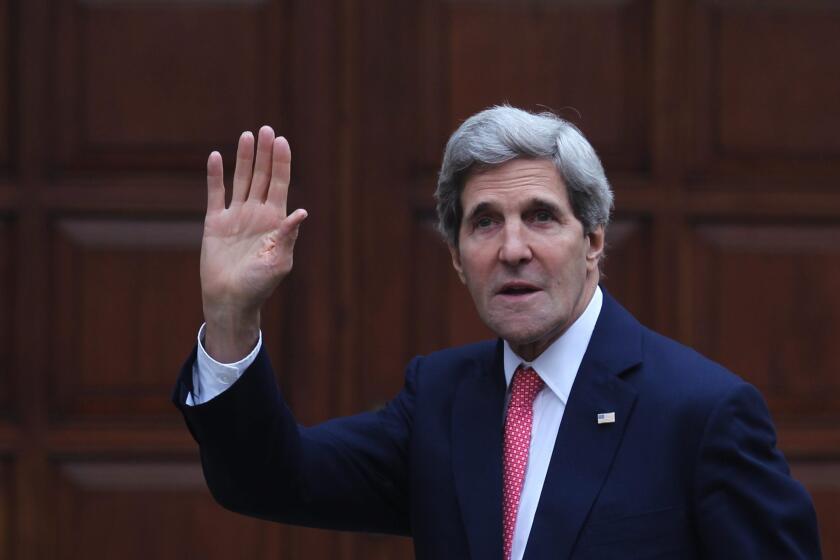 Secretary of State John Kerry, waves as he arrives to the West Bank town of Ramallah for a meeting with the Palestinian President Mahmoud Abbas.