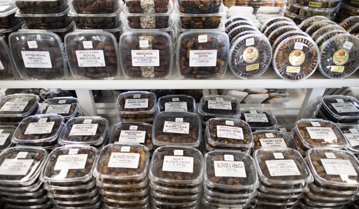 Clear containers filled with dates line two shelves.