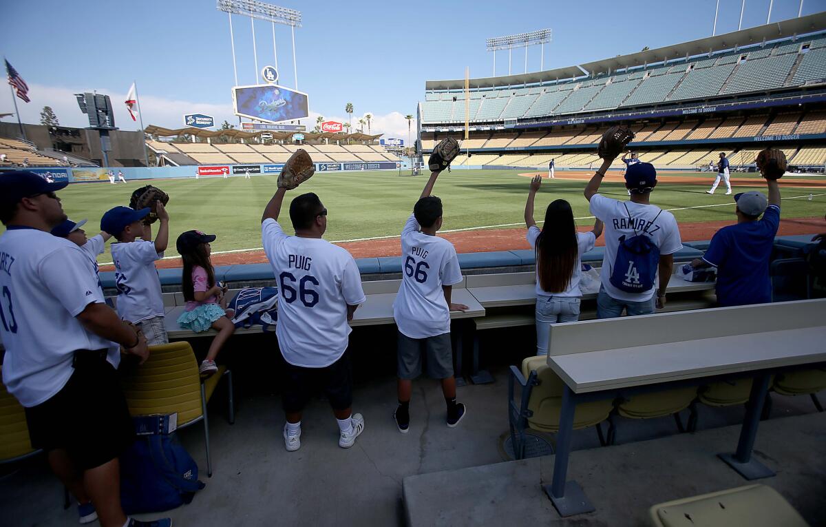 Dodgers fans ask third baseman Juan Uribe (this was 2014) to throw them a pregame souvenir baseball.
