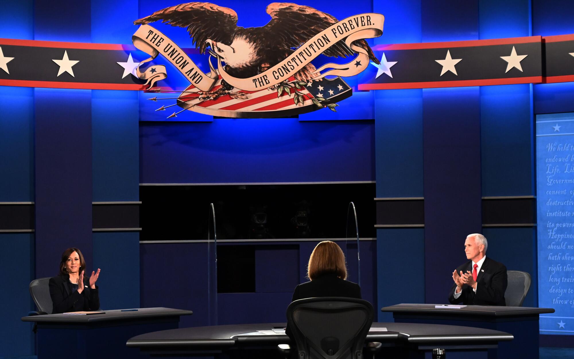 Vice presidential candidates seated behind plexiglass on debate stage