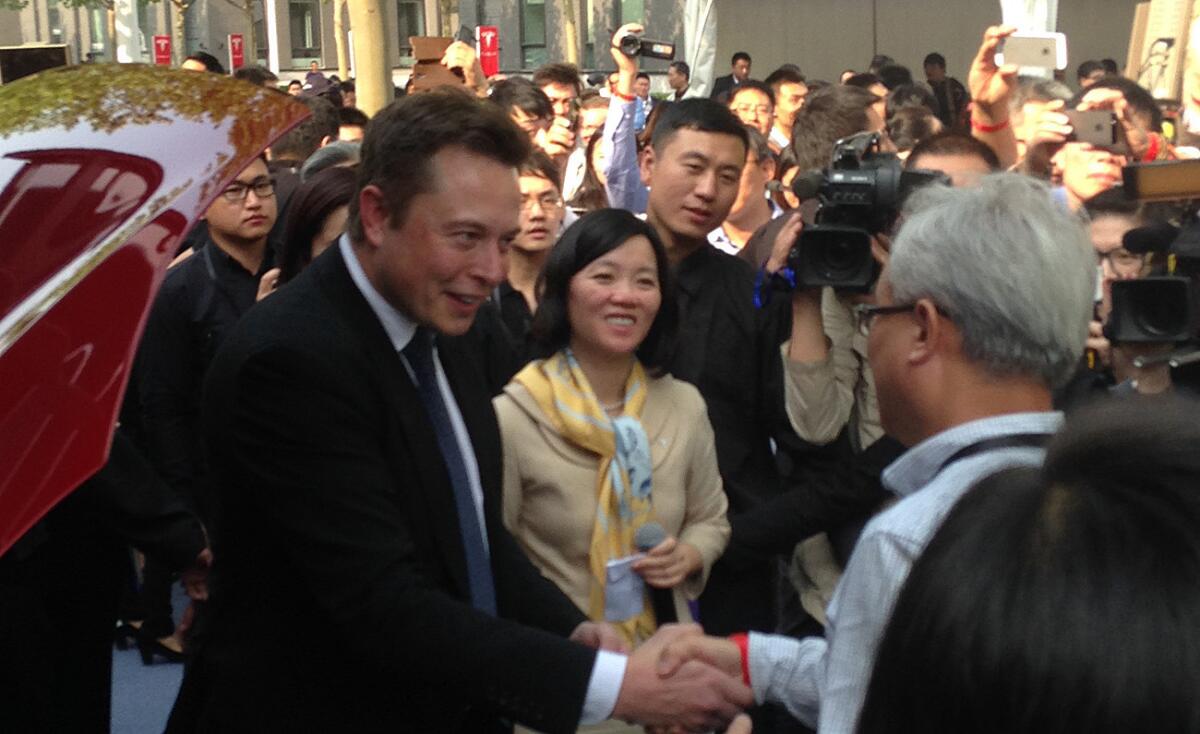 Tesla Chief Executive Elon Musk greets customers in Beijing.