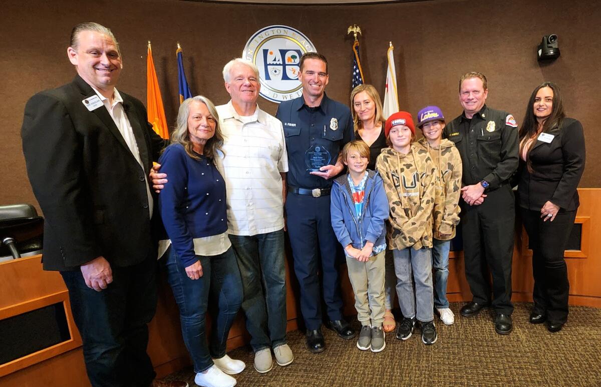 Huntington Beach Fire Inspector Noah Fisher poses with his neighbors after receiving the Mayor's Award in late March.