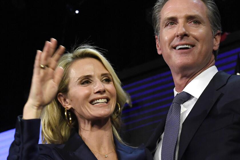 Gavin Newsom and his wife Jennifer Siebel Newsom wave to supporters during an election night event on Nov. 6, 2018, in L.A.