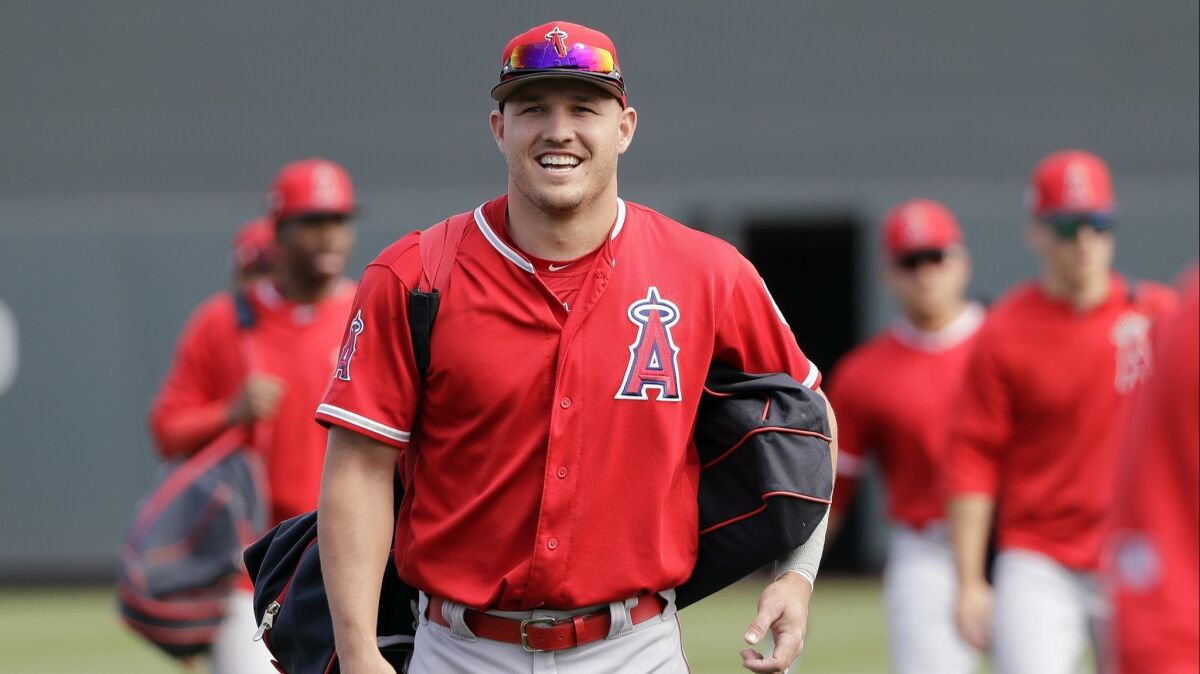 Angels center fielder Mike Trout smiles as he walks onto the field with teammates before a spring training baseball game against the Arizona Diamondbacks on Thursday.