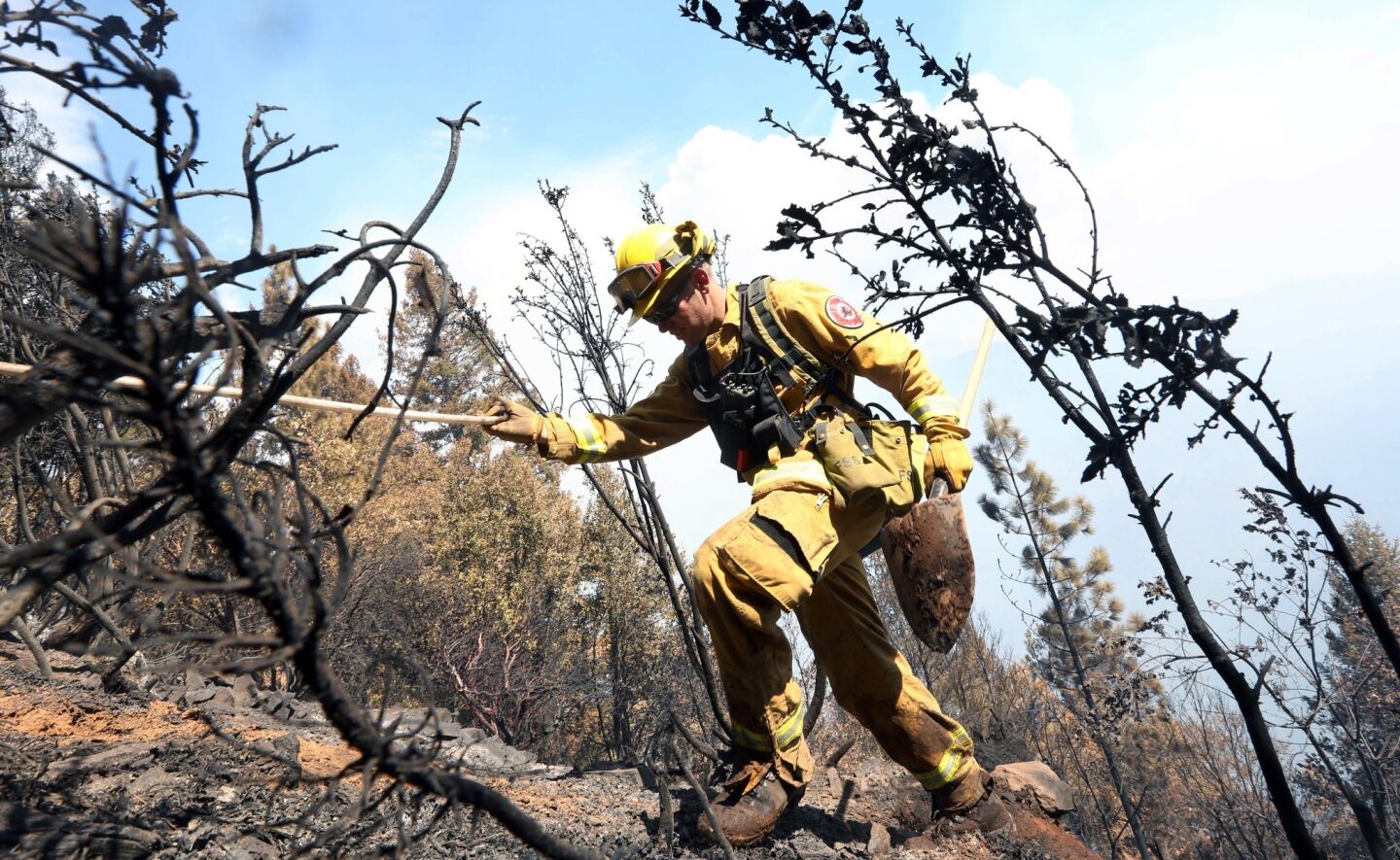 Firefighter Jesse Hadorowski climbs up steep terrain while battling the King fire near Pollock Pines, Calif.. on Sept. 15.