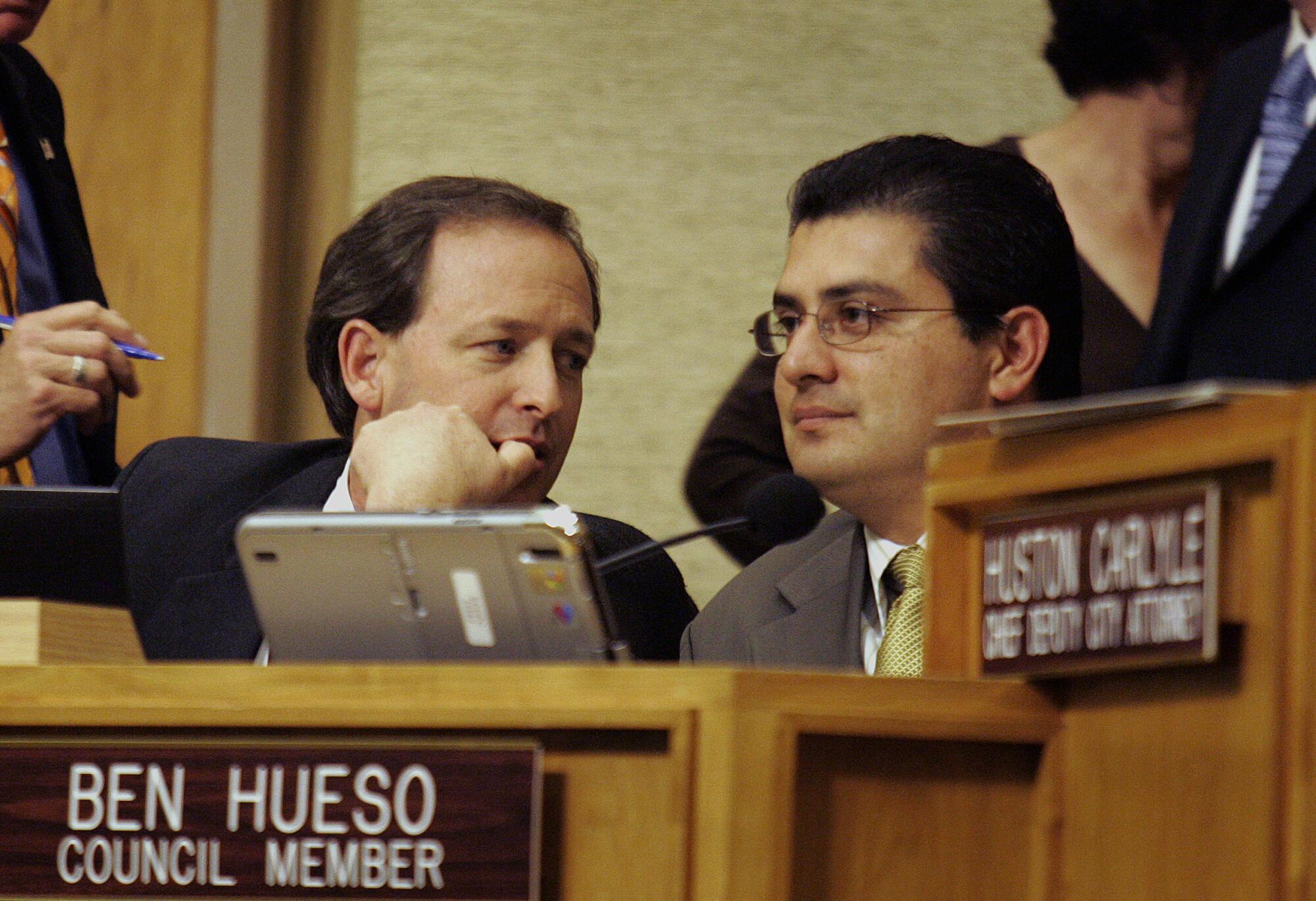 Jim Madaffer and Ben Huseo, then San Diego city councilmen, speak with each other before a vote in 2007.