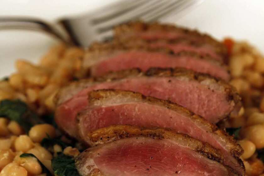 Crisp-skinned duck breast on white beans with Dandelion Greens. Recipe