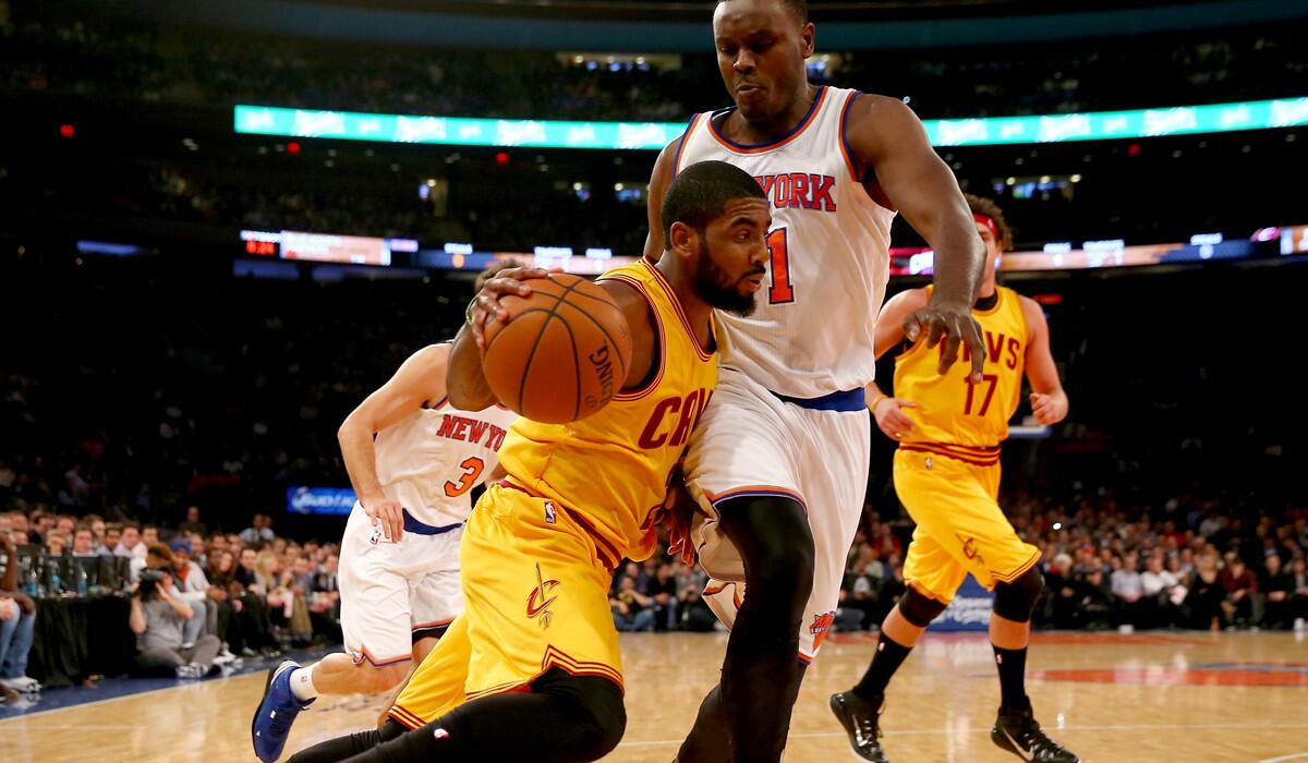 Cavaliers point guard Kyrie Irving tries to drive past Knicks center Samuel Dalembert during their game Thursday night.