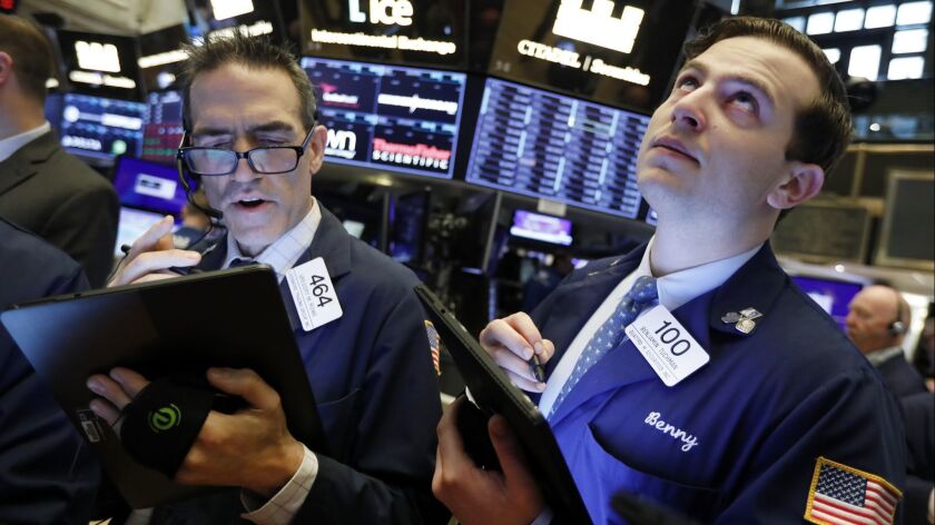 Traders Gregory Rowe and Benjamin Tuchman work on the floor of the New York Stock Exchange on May 9.