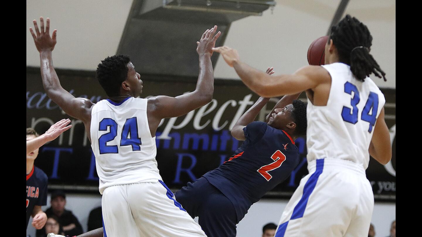 Pacifica Christian's Dominick Harris shoots while falling under pressure from against Saddleback Valley Christian's Tim Adetukasi and Trajan Robinson during a San Joaquin League game on Wednesday, January 31.