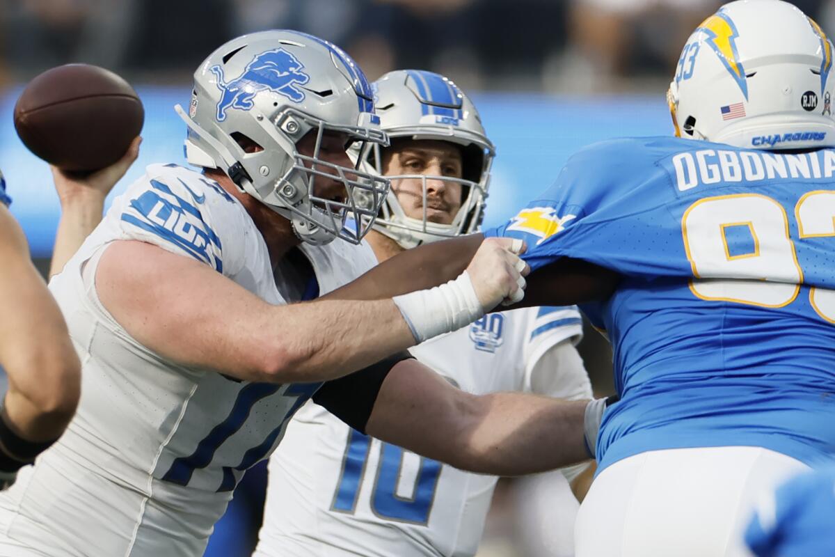Detroit Lions quarterback Jared Goff passes in front of Chargers defensive tackle Otito Ogbonnia.