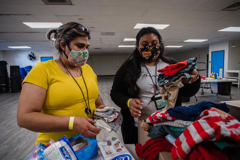Lupita Espinoza (left), and Yvonne Llamas (right) both logistics support specialists prepare kits with clothing, hygiene products and snacks for families at the Jewish Family Service Migrant Shelter in San Diego on February 10, 2021.