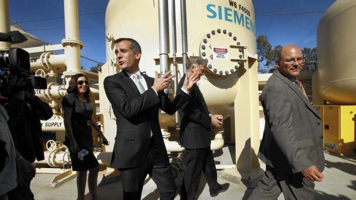 L.A. Mayor Eric Garcetti, center, walks with Department of Water and Power officials at an Arleta facility in 2014.