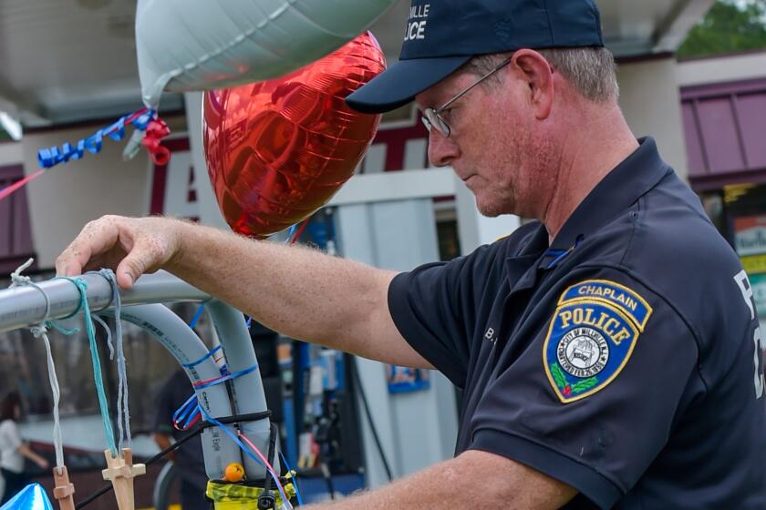 Millville Police Chaplain Robert Ossler stands on Monday, July 18 at a memorial set up outside the gas station where three police officers were killed the day before in Baton Rouge, La.