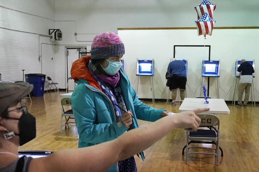 Monica Rojas gets directions from a poll worker on her way to casting her ballot at Sabathani Community Center during municipal elections Tuesday, Nov. 2, 2021, in Minneapolis. Voters in Minneapolis are deciding whether to replace the city’s police department with a new Department of Public Safety. The election comes more than a year after George Floyd’s death launched a movement to defund or abolish police across the country.(David Joles /Star Tribune via AP)