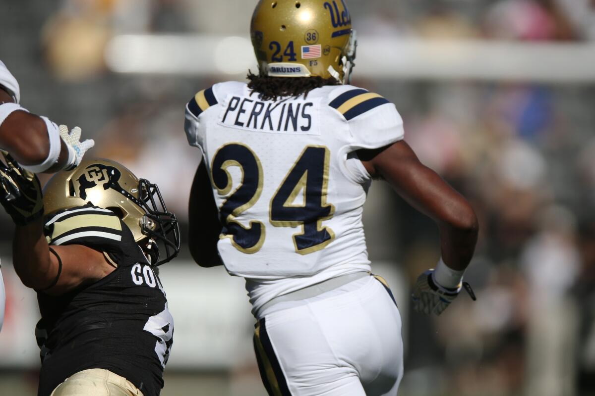 UCLA running back Paul Perkins breaks past Colorado defensive back Chidobe Awuzie en route to a 92-yard touchdown against the Buffaloes on Saturday.