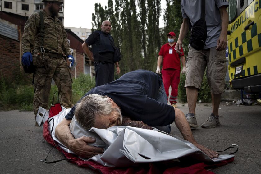 Viktor Kolesnik cries on a body of his wife Natalia Kolesnik, who was killed during a Russian bombardment at a residential neighborhood in Kharkiv, Ukraine, on Thursday, July 7, 2022. (AP Photo/Evgeniy Maloletka)