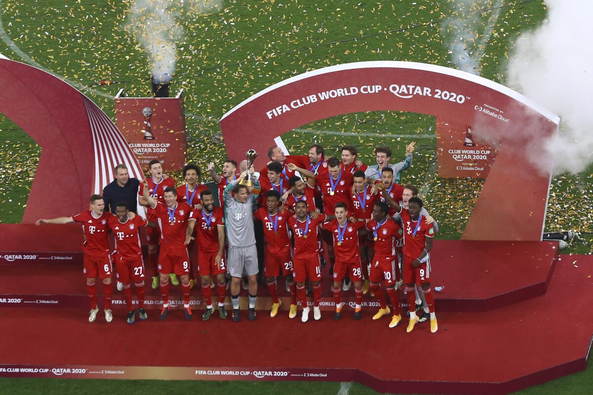 FILE - Bayern's goalkeeper Manuel Neuer holds up the trophy as celebrates with his teammates winning the Club World Cup final soccer match between FC Bayern Munich and Tigres at the Education City stadium in Al Rayyan, Qatar, Thursday, Feb. 11, 2021. Bayern Munich fans have been stepping up their public criticism of the club for its ties to World Cup host Qatar. Bayern supporters displayed a huge banner during the team’s home Bundesliga game on Saturday, Nov. 6, 2021 criticizing their club for what they say is its “sports-washing” of alleged human rights abuses in Qatar by accepting sponsorship from national airline Qatar Airways and holding mid-season team training camps in the Persian Gulf country since 2011. (AP Photo, File)