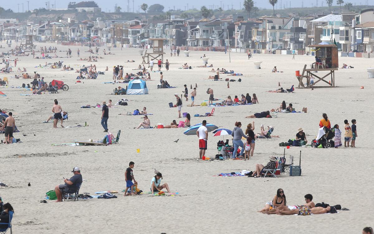 Beachgoers enjoy a warm day north of the Newport Beach Pier on Thursday as Gov. Gavin Newsom announced a "hard close" of state and local beaches in Orange County.