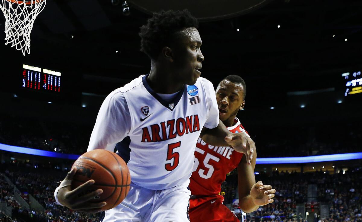 Arizona forward Stanley Johnson controls the ball against Ohio State center Trey McDonald during the first half of the Wildcats' 73-58 victory over the Buckeyes in a third round game of the NCAA tournament.