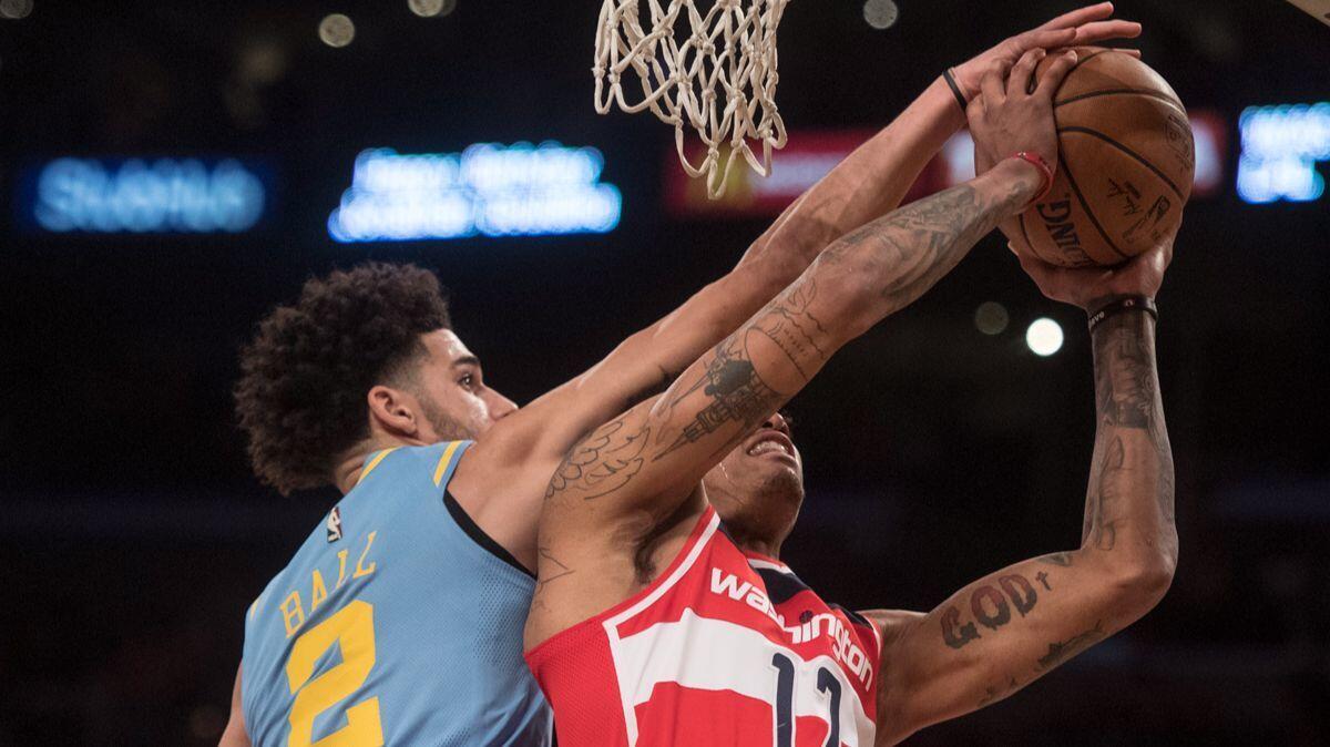 Lakers guard Lonzo Ball, left, blocks the shot by Washington Wizards forward Kelly Oubre Jr. during the first half on Wednesday.