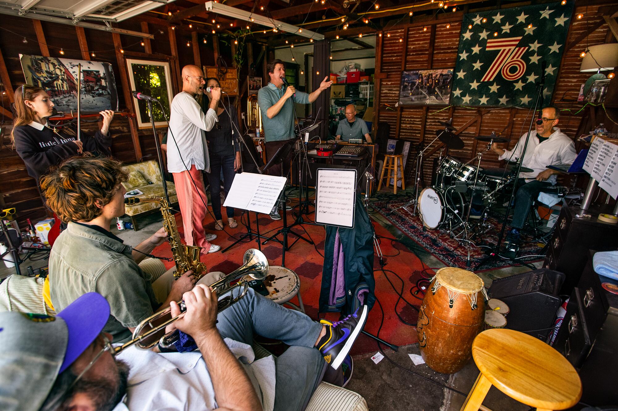 A group of people practicing music in a garage.