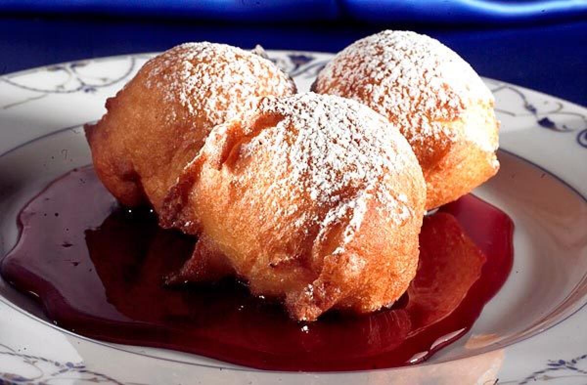 Fried foods -- like bumuelos in red wine syrup -- take center stage during Hanukkah.