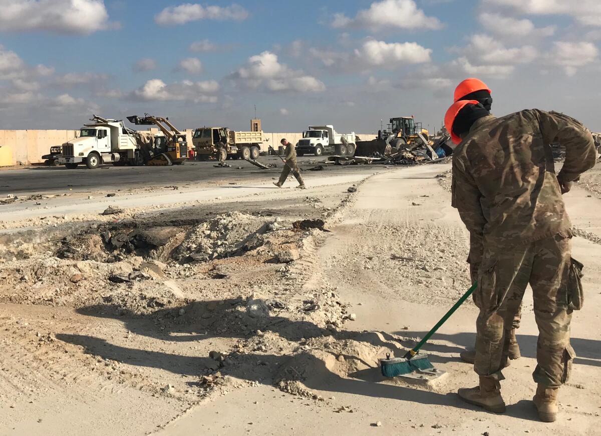 Troops clean some of the debris in the aftermath of an Iranian ballistic missile on the Al-Asad Airbase in the western Iraqi province of Anbar.