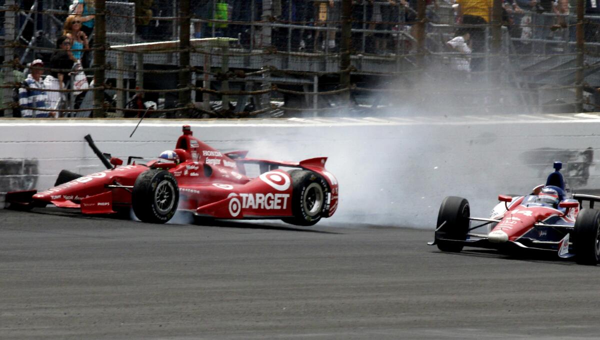 Dario Franchitti, left, hits the wall to bring out the final caution during Indianapolis 500.