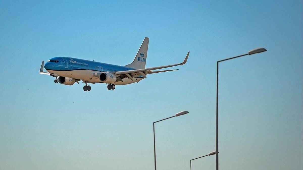 A KLM plane prepares to land at Humberto Delgado airport in Lisbon. KLM and other airlines let you buy carbon offsets.