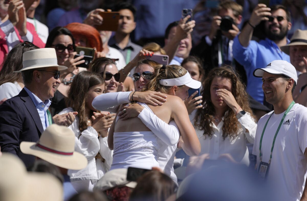 Kazakhstan's Elena Rybakina is embraced by family, friends and coaches in the players box as she celebrates after beating Tunisia's Ons Jabeur to win the final of the women's singles on day thirteen of the Wimbledon tennis championships in London, Saturday, July 9, 2022. (AP Photo/Kirsty Wigglesworth)