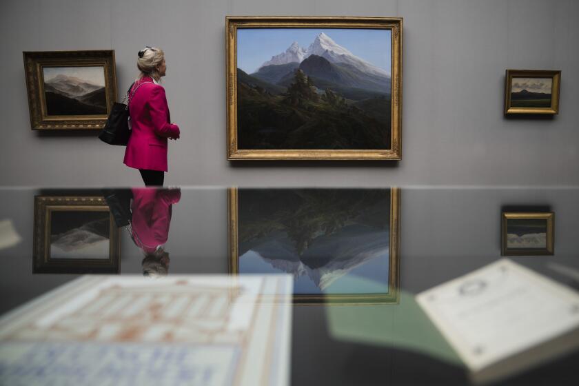 A woman looks to Caspa David Friedrich's painting 'The Watzmann' during a press preview of the exhibition 'Caspar David Friedrich. Infinite Landscapes' at the Alte Nationalgalerie museum in Berlin, Germany, Wednesday, April 17, 2024. A major show of Caspar David Friedrich's iconic landscapes that marks the 250th anniversary of his birth is opening in Berlin, the city where he made his breakthrough and where an exhibition in 1906 kicked off an an enduring revival in interest in the German Romantic master. (AP Photo/Markus Schreiber)