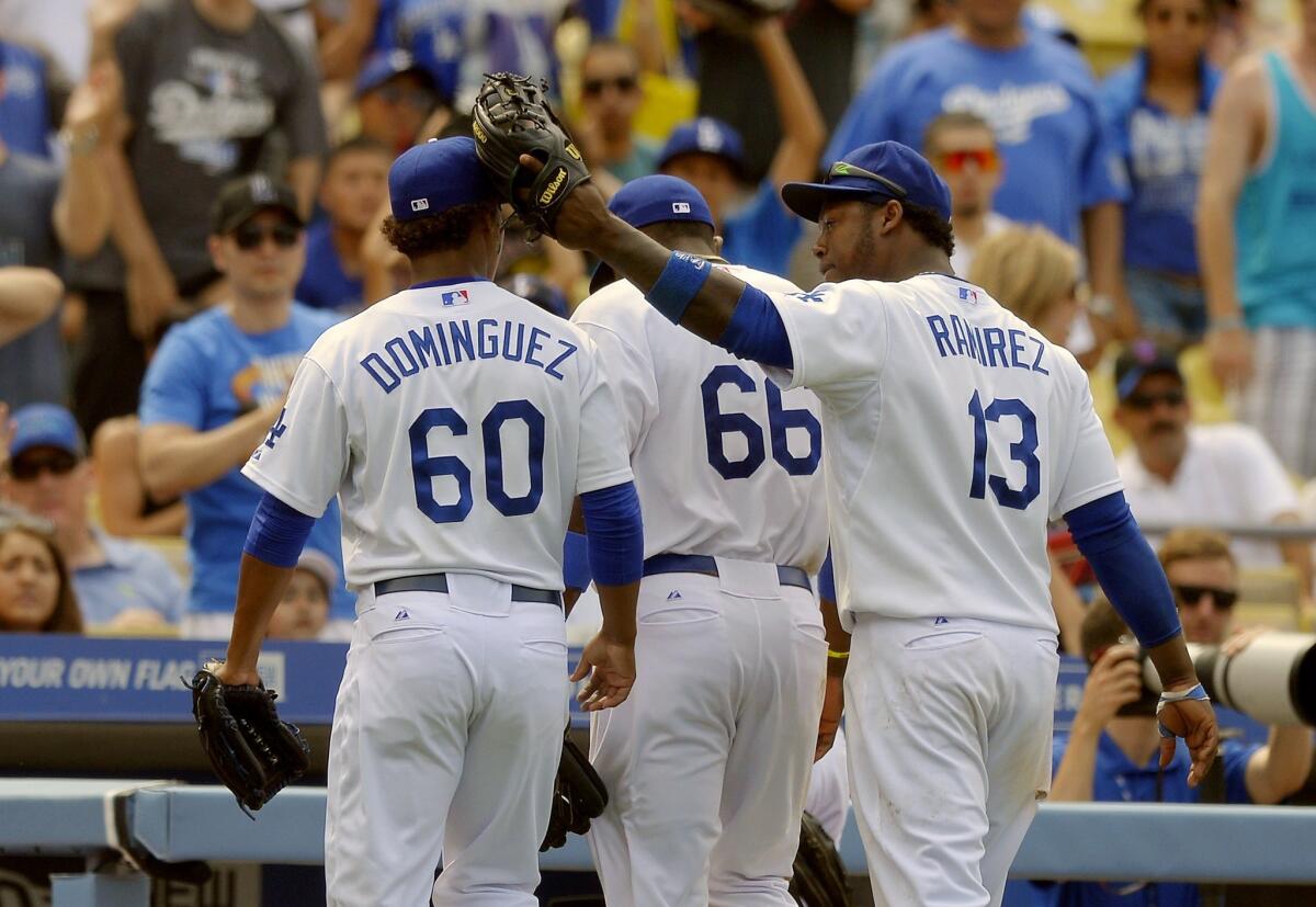 Dodgers reliever Jose Dominguez, left, is congratulated by teammate Hanley Ramirez, right, as Yasiel Puig walks away during the Dodgers' 6-1 win over the Philadelphia Phillies.