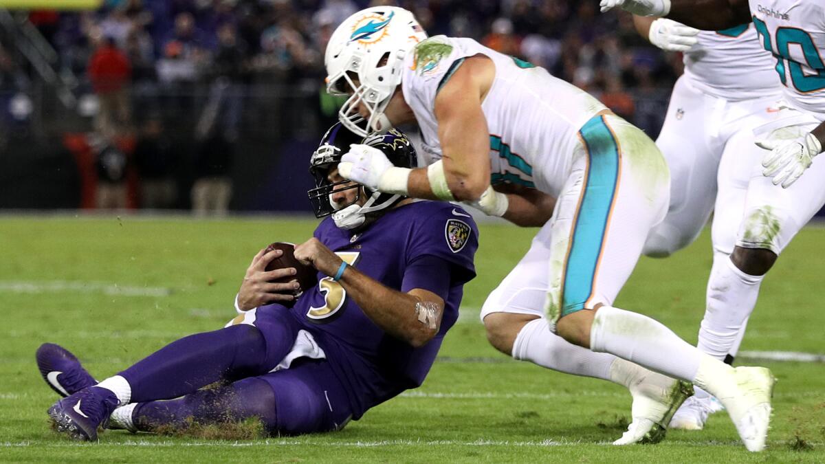 Dolphins linebacker Kiko Alonso is about to clobber Ravens quarterback Joe Flacco as he slides after scrambling down field during their game Thursday night. Flacco would sustain a concussion.