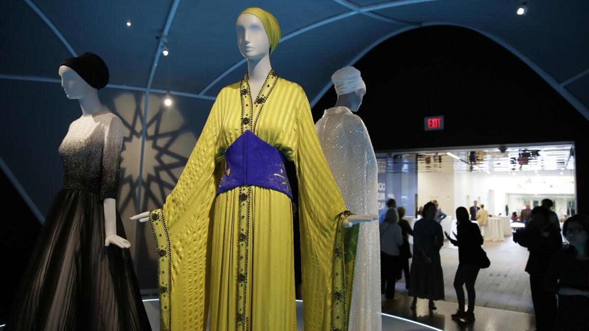 A spring 2016 Jean Paul Gaultier gown belt and turban, center, on loan to the exhibition from Sheikha Moza bint Nasser of Qatar.