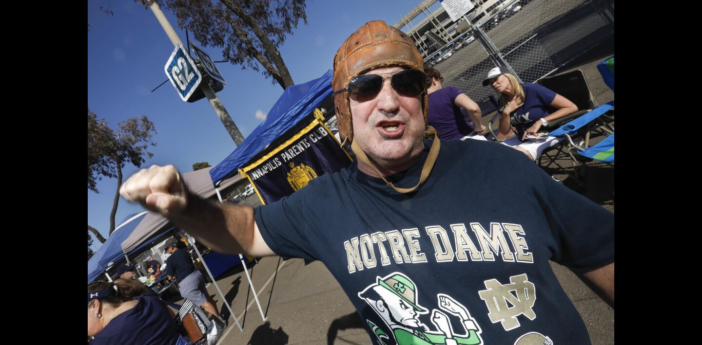 Wearing a vintage football helmet, Notre Dame fan Andy Powers of Oceanside gets ready for the game against Navy at SDCCU Stadium.