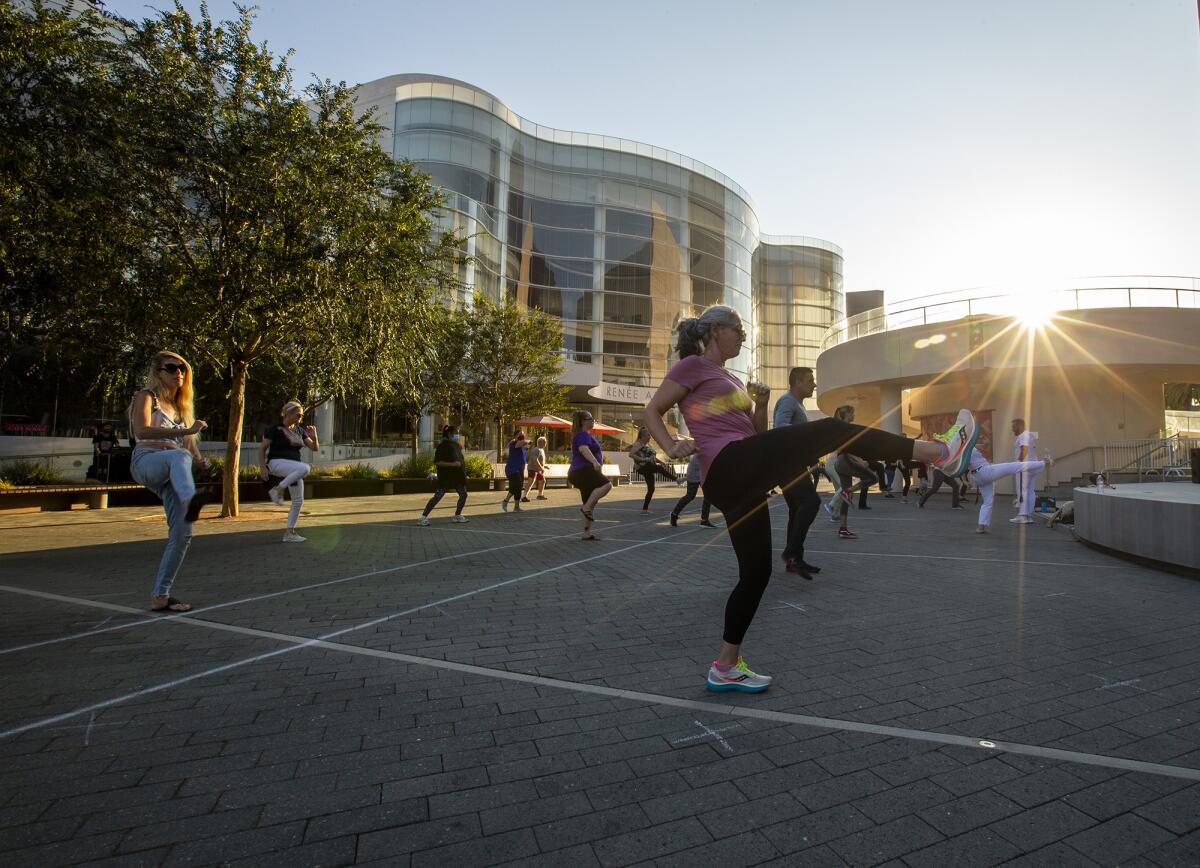Kelsie Anderson, right, and others participate in a Brazilian capoeira class at Segerstrom Center's Argyros Plaza.