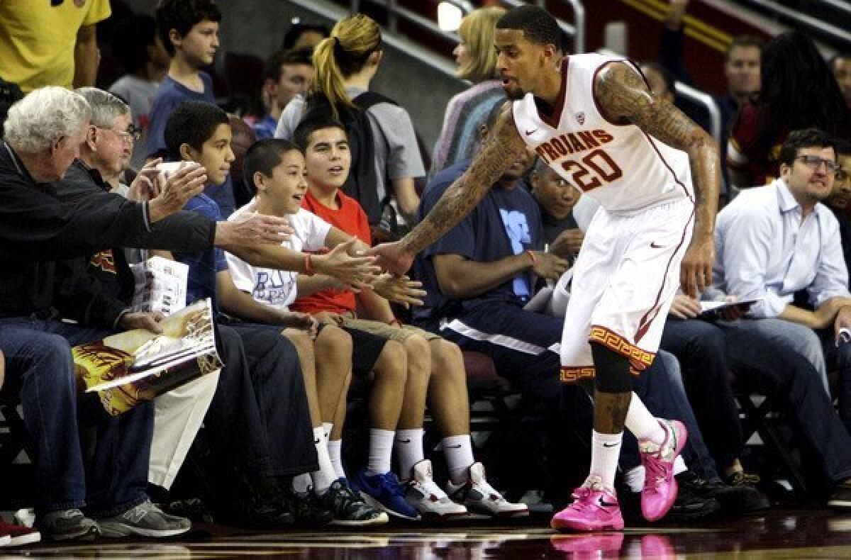 USC guard J.T. Terrell high-fives fans courtside after a scrimmage at Galen Center.