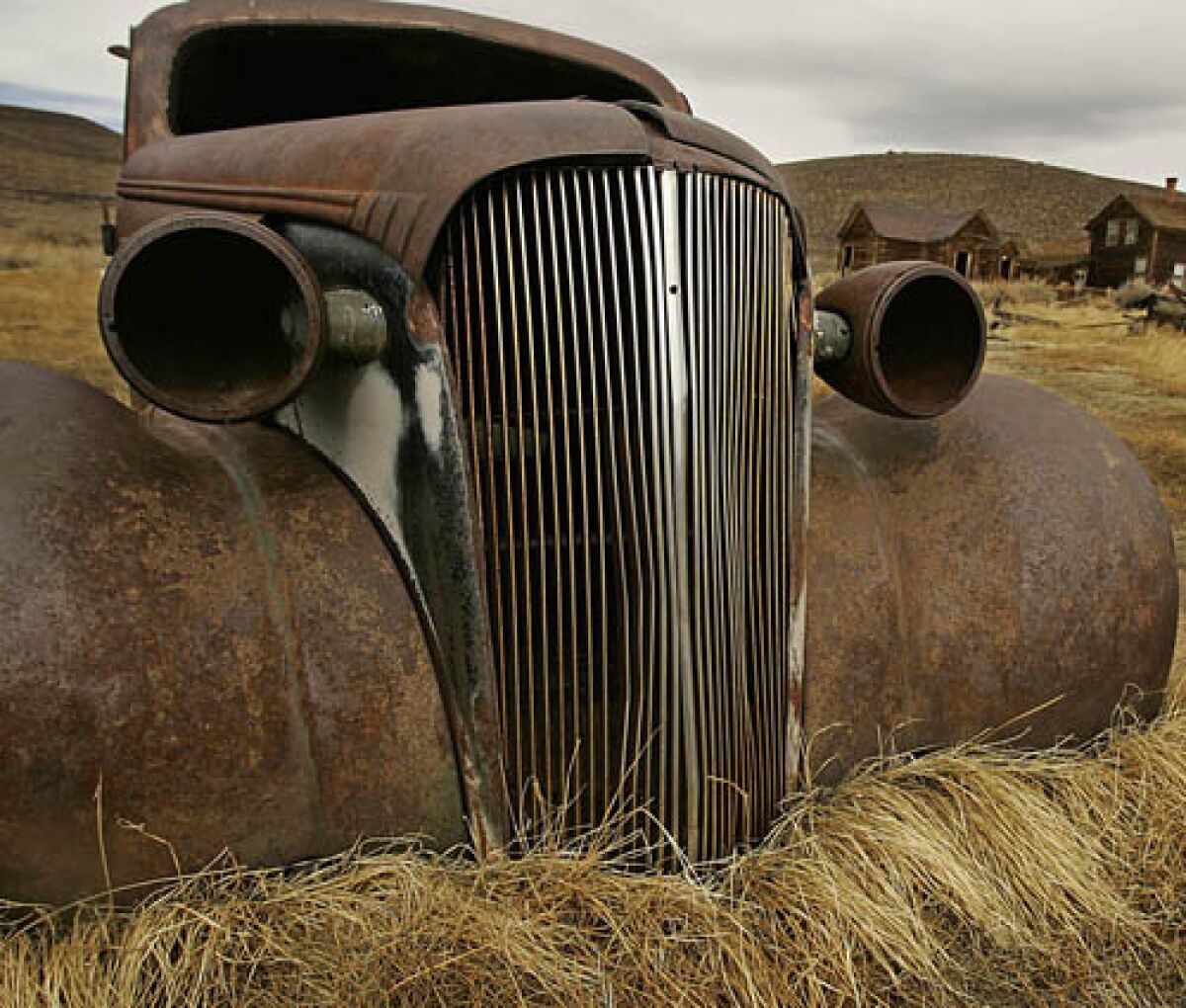 An old rusted car in a dry field