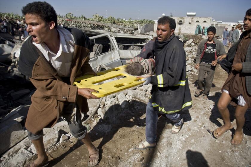 Men carry the body of a child they uncovered from rubble of houses destroyed by Saudi airstrikes near Sana Airport in Yemen on March 26.