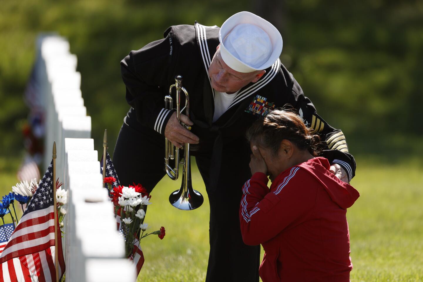 Retired U.S. Navy Yeoman 1st Class Mark Stallins consoles a woman at Ft. Logan National Cemetery .