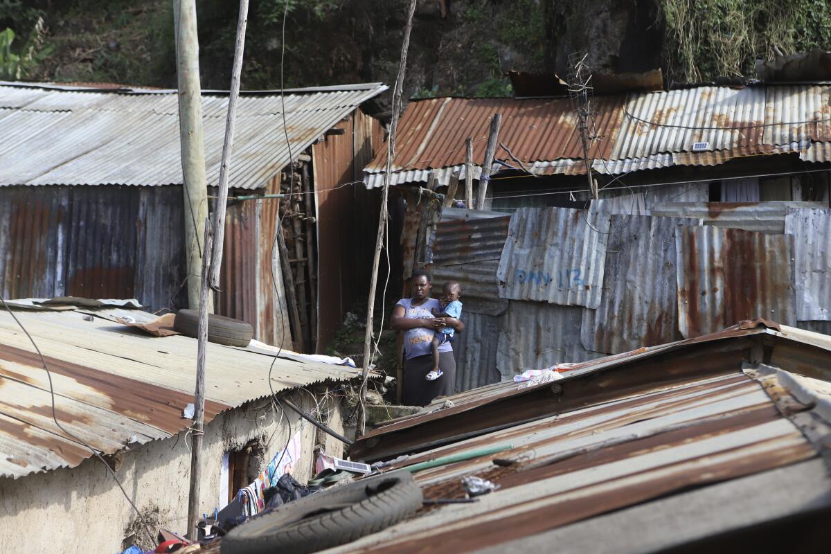 Jacinter Awino, 33, carries her son in the Kibera slum of the capital Nairobi, Kenya.