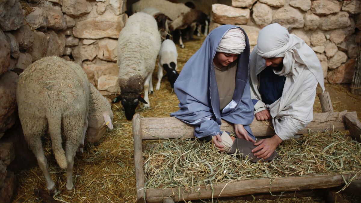 Christian actors portray Mary and Joseph with the baby Jesus during a reenactment of the Nativity at an outdoor museum in Nazareth, Israel.