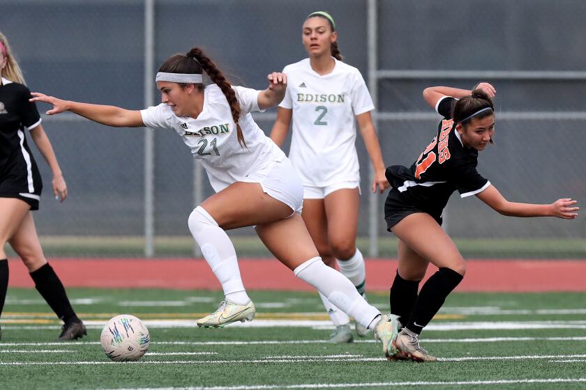 EdisonOs Olivia Green (21) battles against Huntington BeachOs Grace Cogan, right, during the first half of the Best in the West Finals on Saturday at Bolsa Grande High School in Garden Grove. (Kevin Chang / Daily Pilot)
