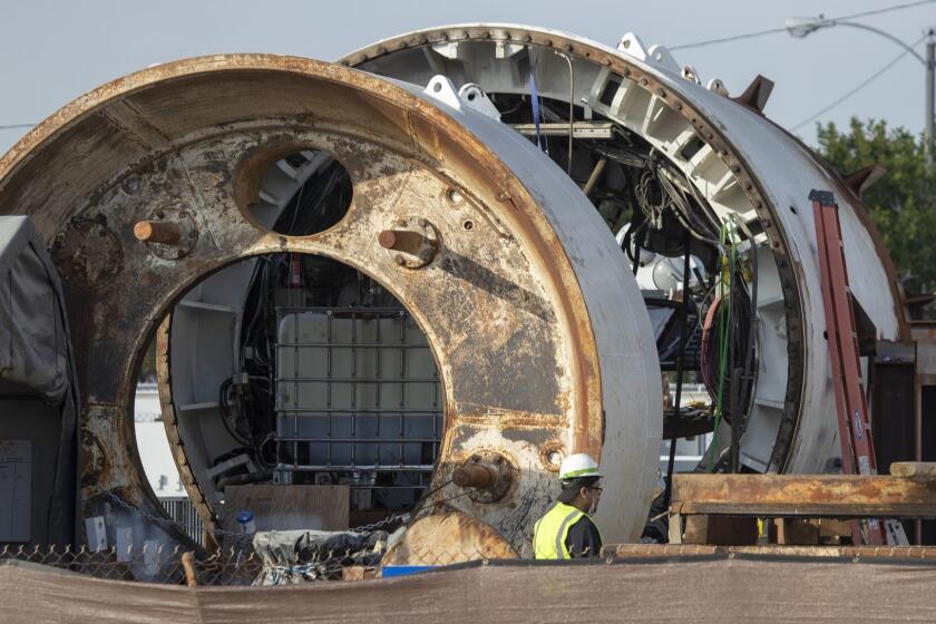 HAWTHORNE, CALIF. -- MONDAY, DECEMBER 17, 2018: Construction workers work on the Boring Company's tunnel entrance across the street from SpaceX headquarters and next to the Dominguez Channel in Hawthorne Monday, Dec. 17, 2018. Elon Musk's tunnel project n Hawthorne is slated to open Tuesday. (Allen J. Schaben / Los Angeles Times)