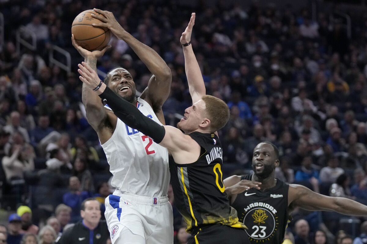 Clippers forward Kawhi Leonard is fouled by Golden State Warriors guard Donte DiVincenzo.