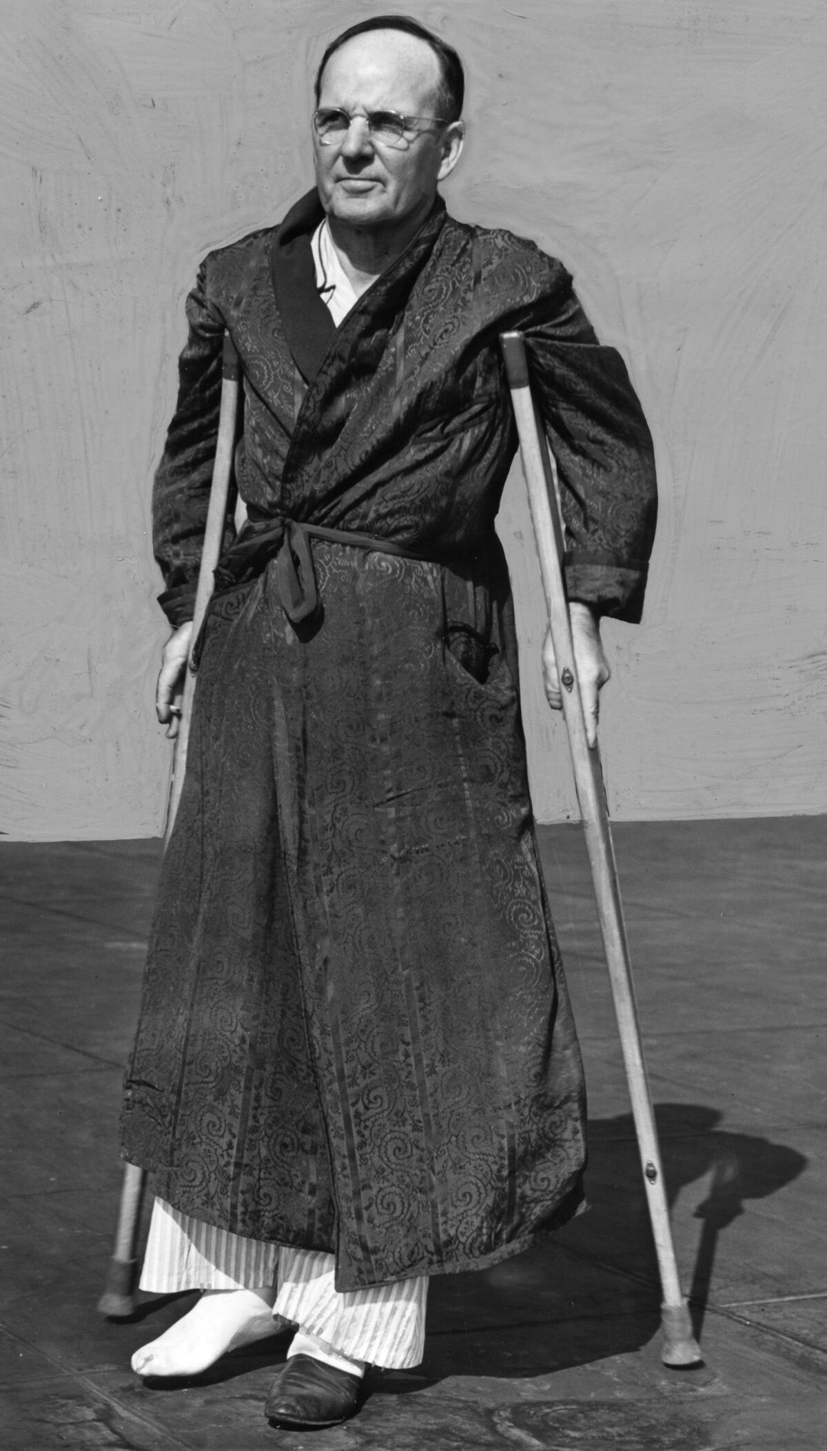 Black and white photo shows Harry Raymond on crutches.