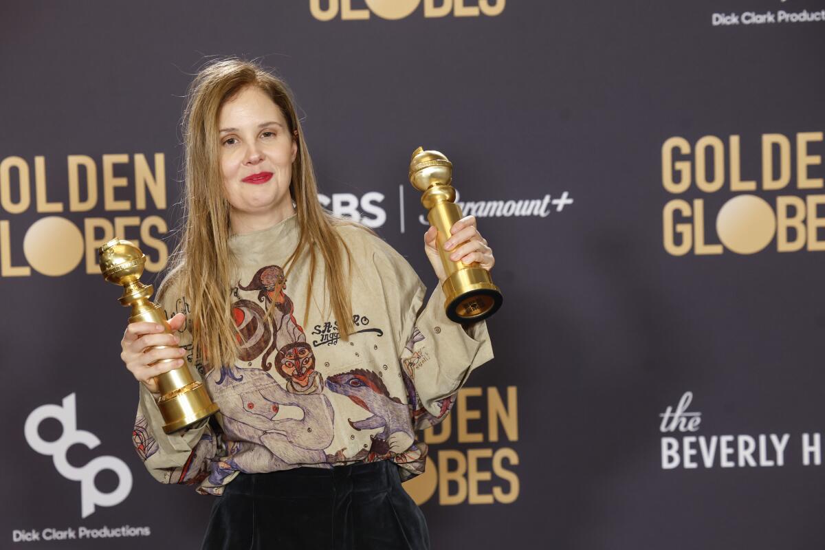 Director Justine Triet poses with the Golden Globes for screenplay and non-English language film for "Anatomy of a Fall."