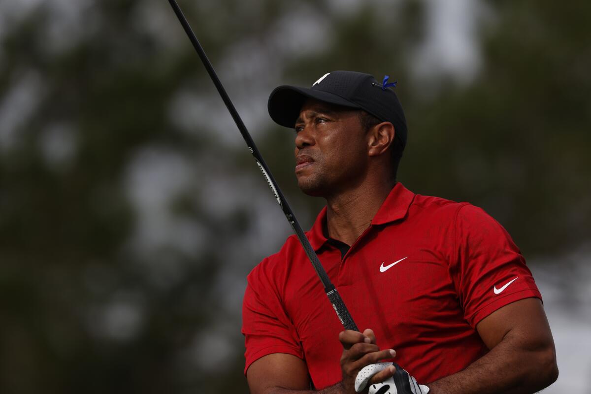 Tiger Woods watches his ball's flight after hitting a tee shot