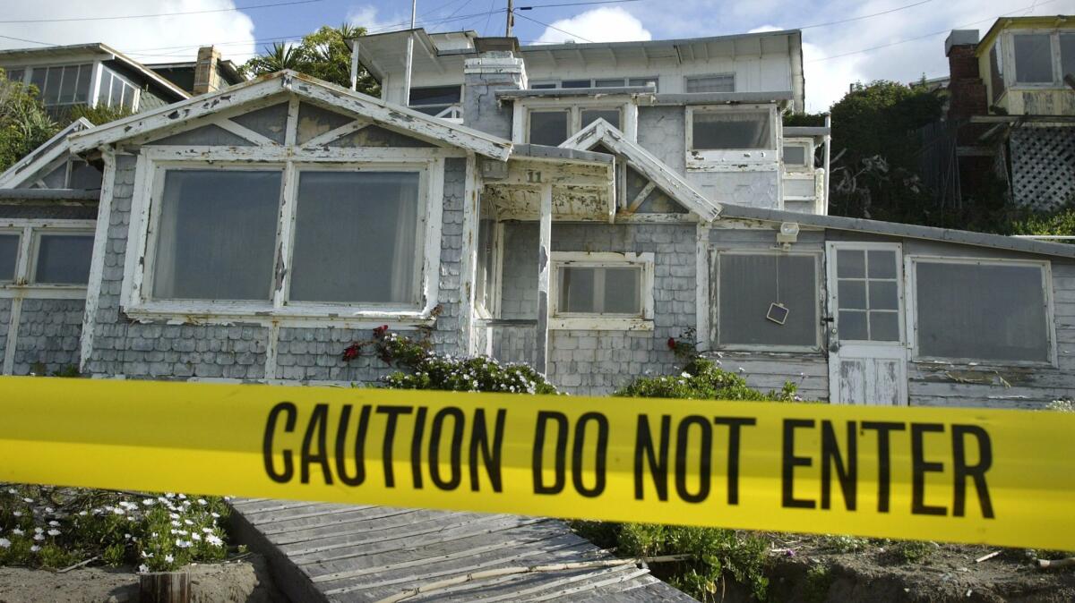 Caution tape keeps people out of dilapidated cottages along the beach at historic Crystal Cove State Park in Orange County.